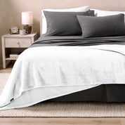 Bed with grey sheets and a sherpa blanket