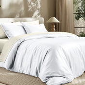 Bedding set on a bed in a bedroom with a lamp and window.