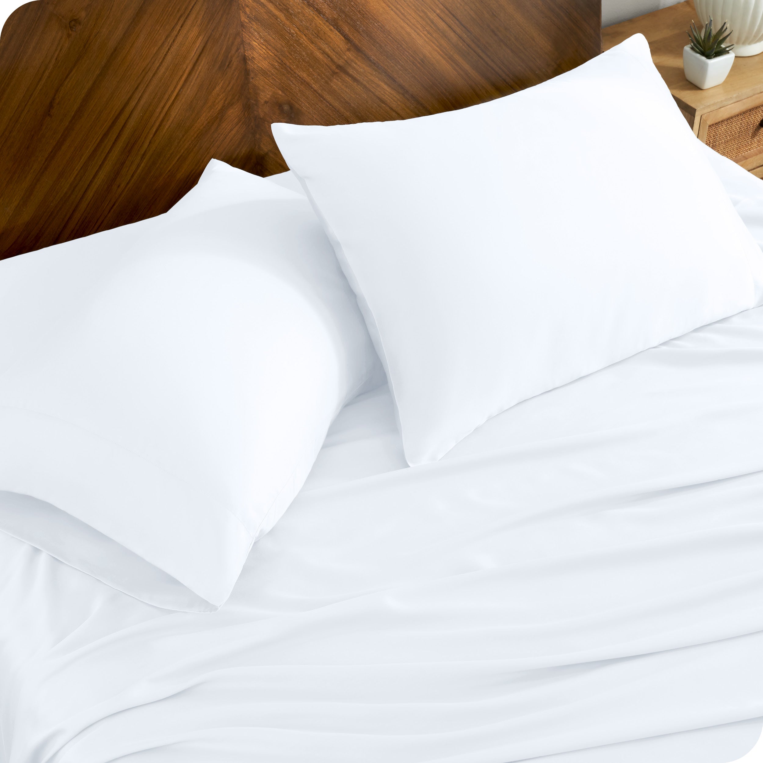 TENCEL™ pillowcases on pillows near a wooden headboard