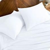 TENCEL™ pillowcases on pillows near a wooden headboard