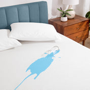 A glass of water spilled on a bed covered with a mattress protector