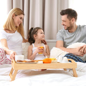 A family sitting in bed with breakfast on a tray