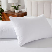 Close up of two pillows on a mattress. There are pillow protectors on the pillows.