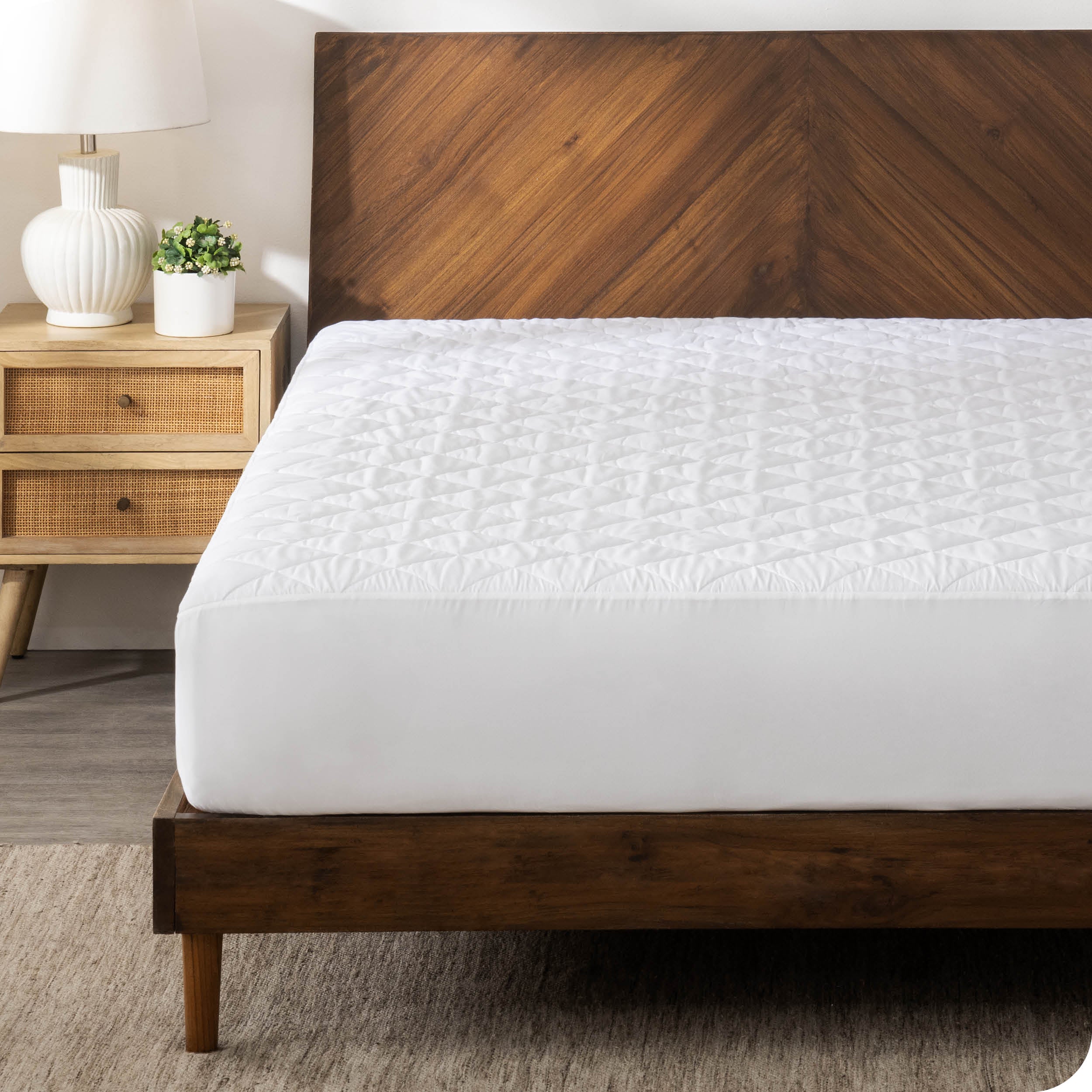 A mattress pad on a bed with a wooden bed frame