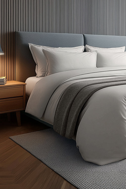 Modern bedroom with a neatly made bed, desk, and chair.