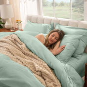 Woman sleeping on a bed made with percale sheets and duvet cover