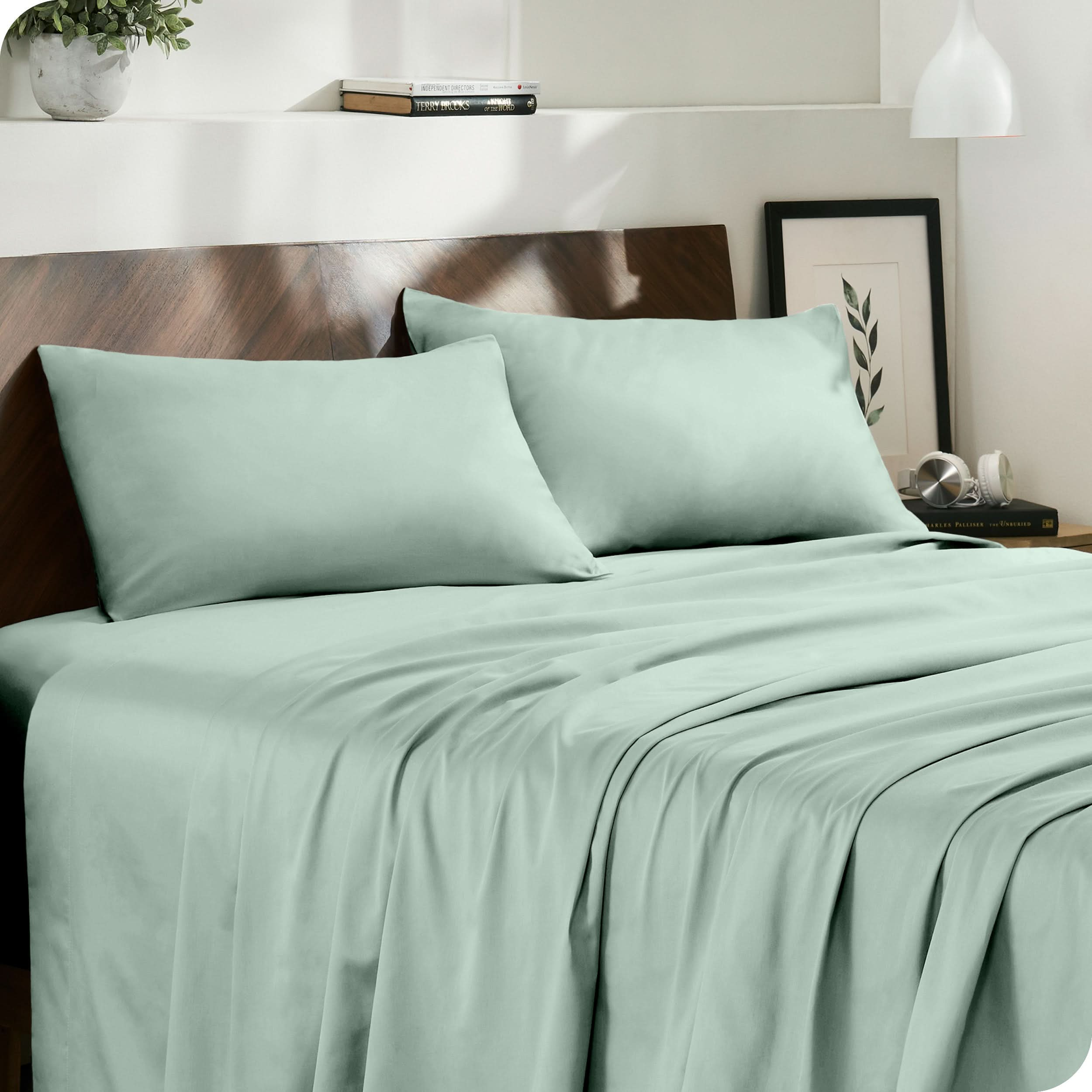 Diagonal view of modern bedroom with sateen sheets and pillowcases on the bed