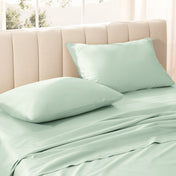 Sateen bedding set on a bed with a beige headboard.
