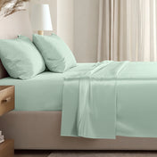Sateen sheet set on a bed in a softly lit bedroom.