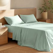 Bed with percale bedding and wooden headboard in a bedroom setting