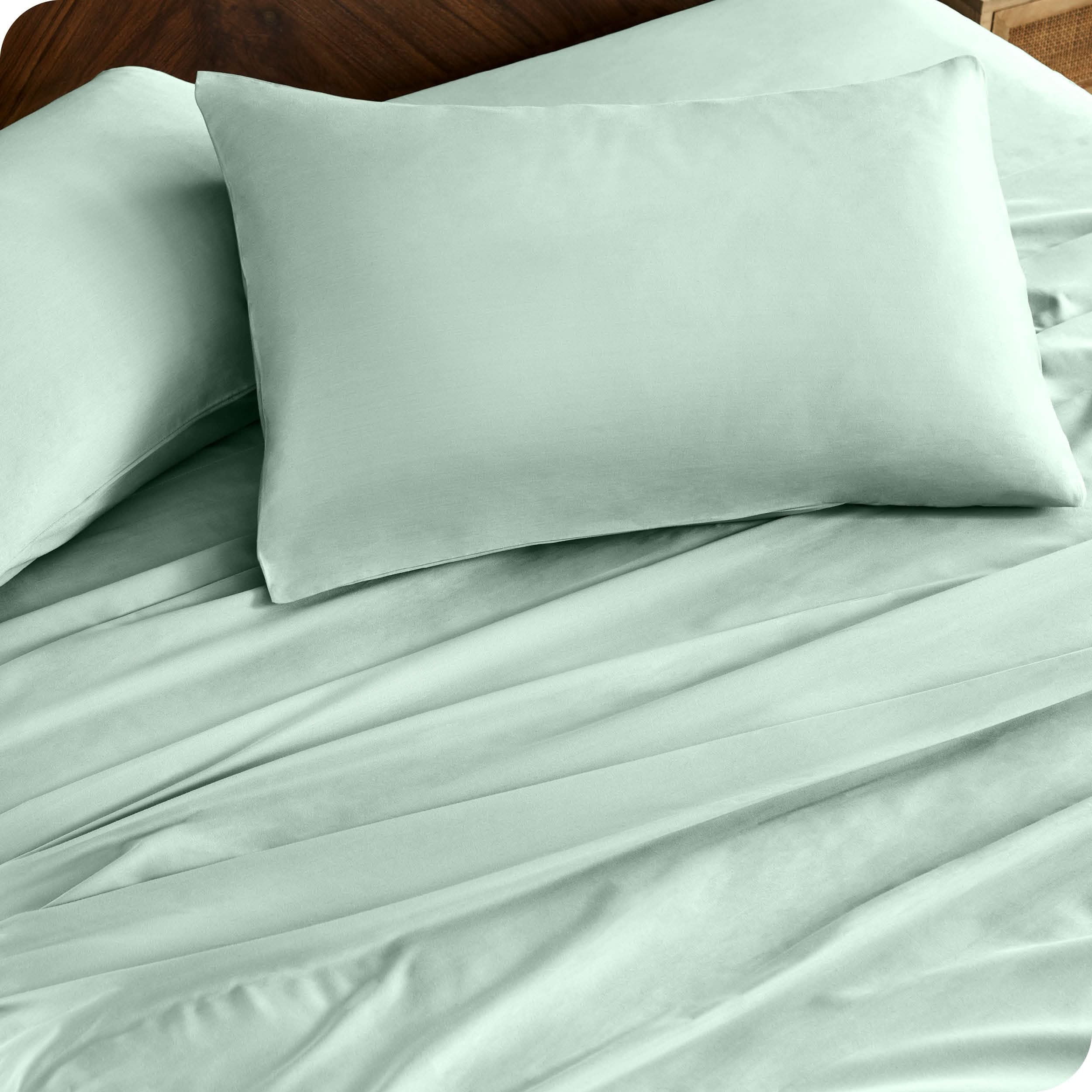 Close up of percale pillowcases and sheets on a bed