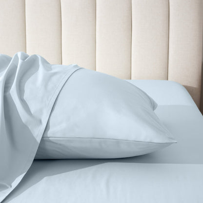 Pillow on a bed with a neutral headboard