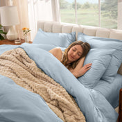 Woman sleeping on a bed made with percale sheets and duvet cover