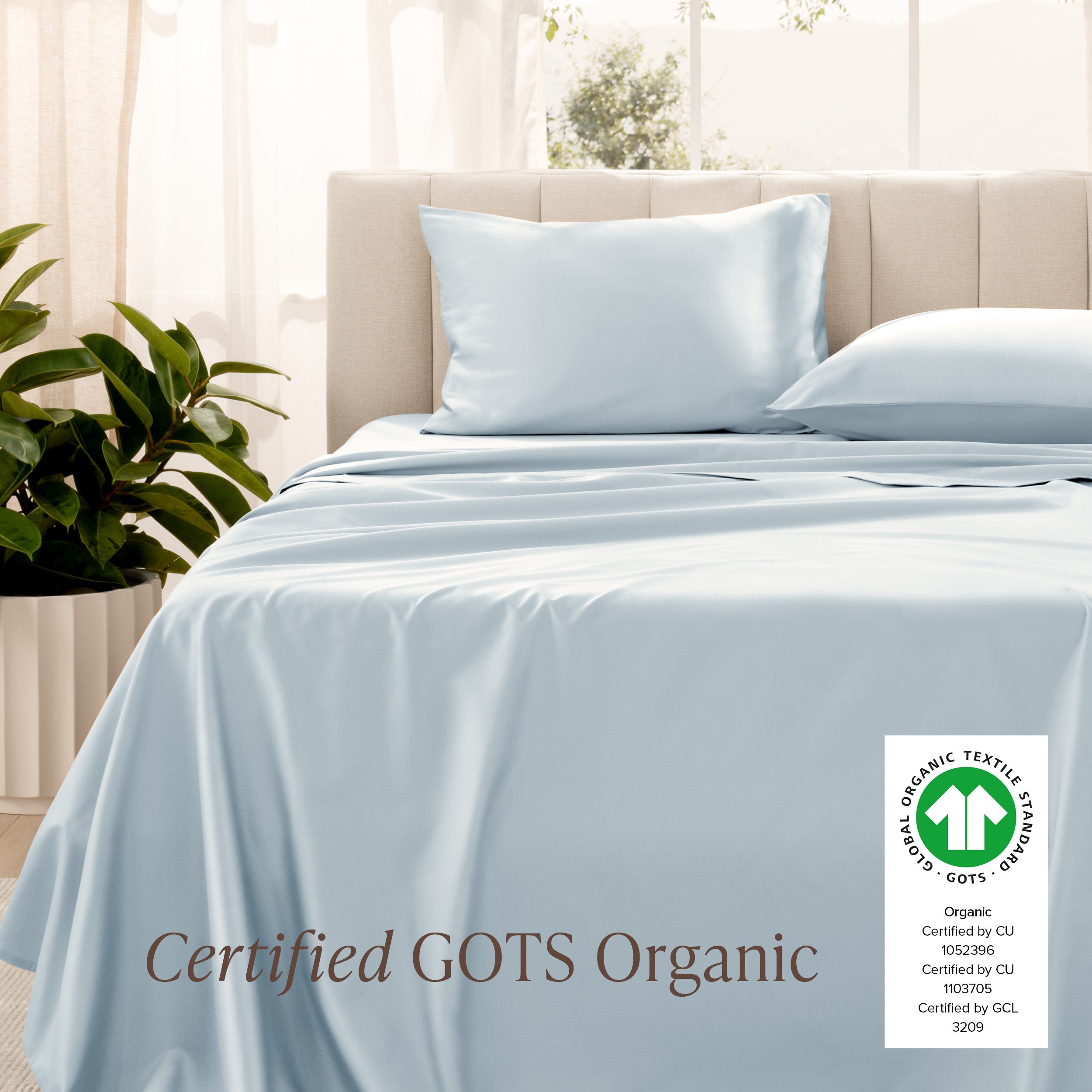 Bed with sateen bedding and pillowcases, featuring a GOTS Organic certification label.