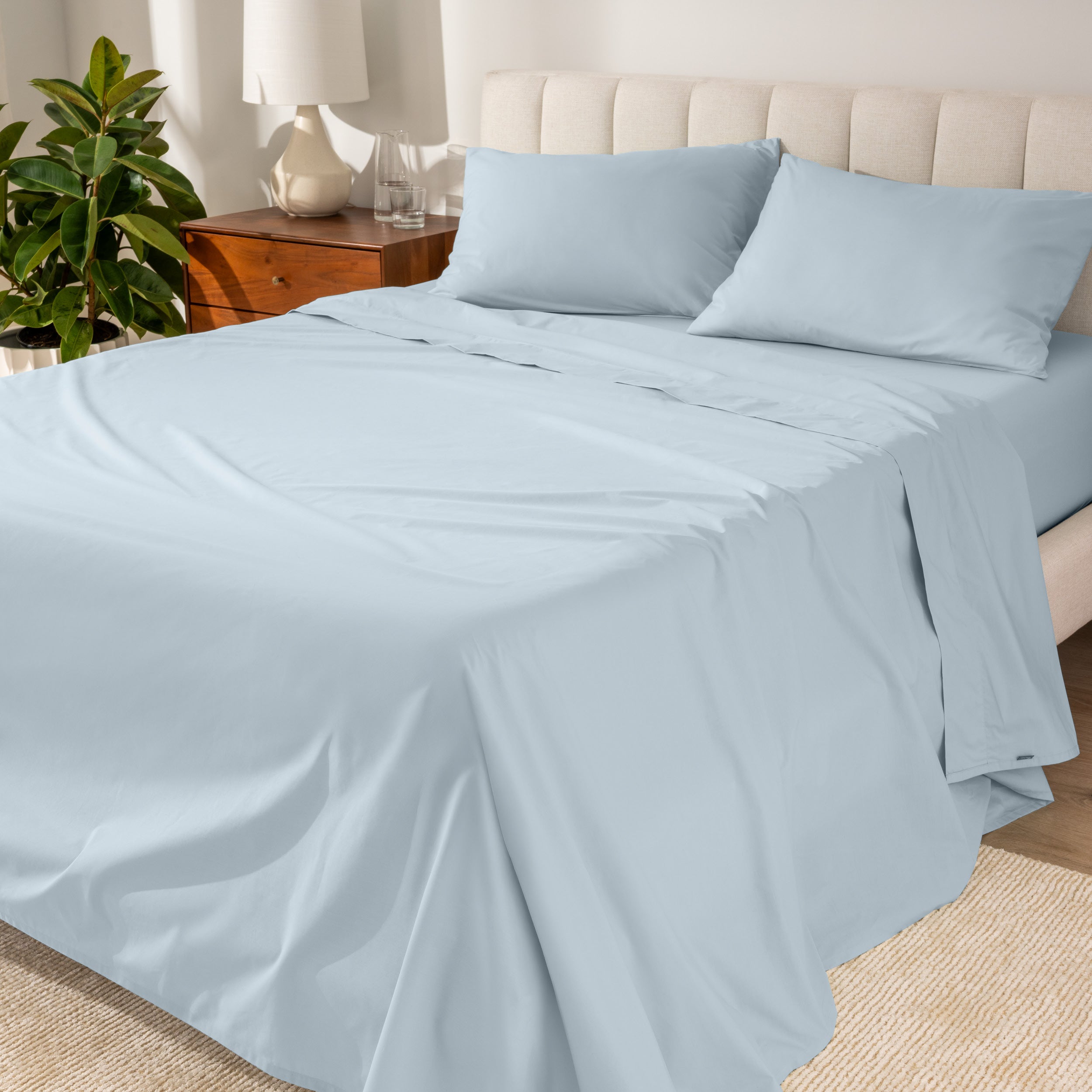 Percale sheets on a bed with a cream colored frame and headboard