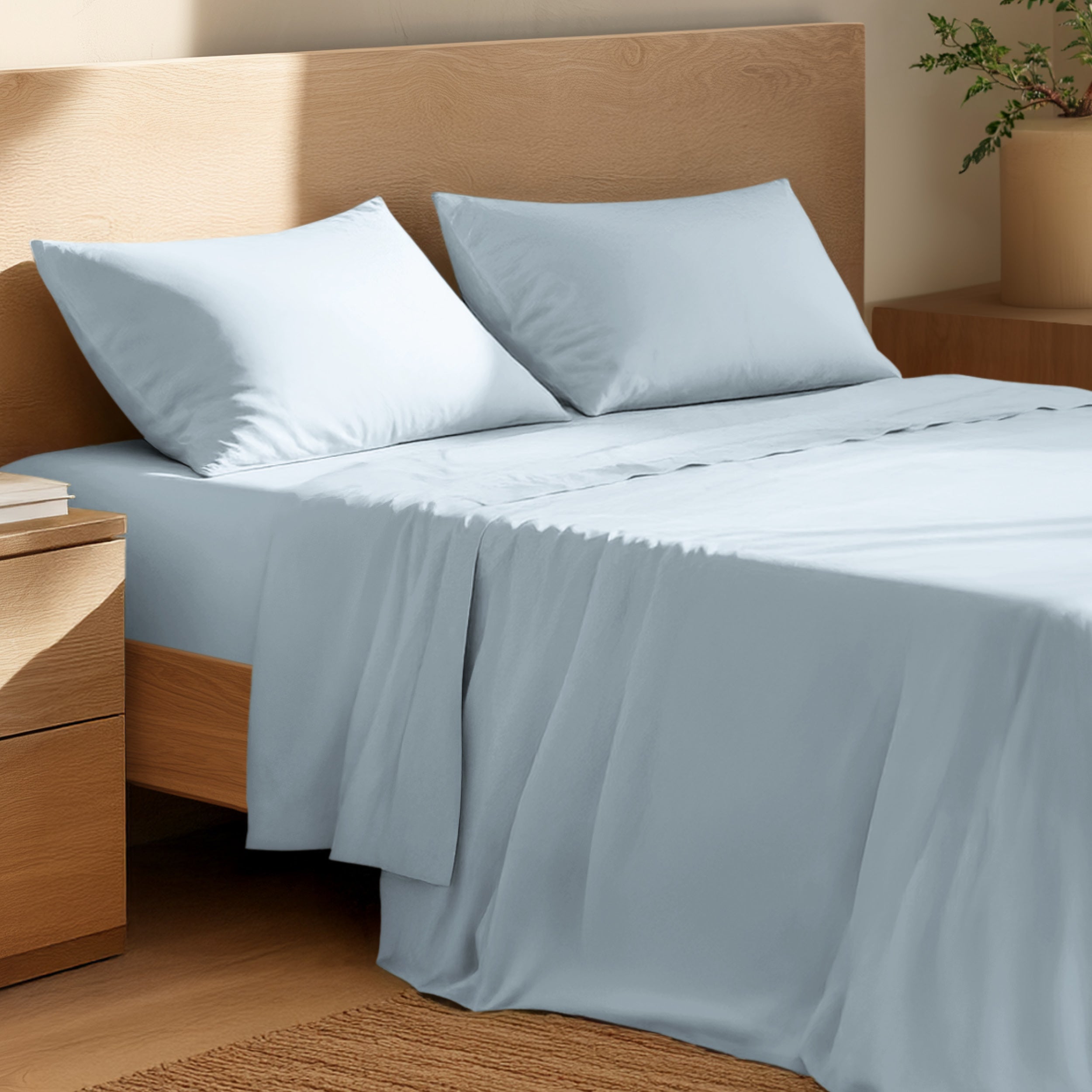 Bed with percale bedding and wooden headboard in a bedroom setting