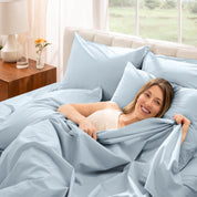 Woman lying in bed with percale bedding in a bright bedroom