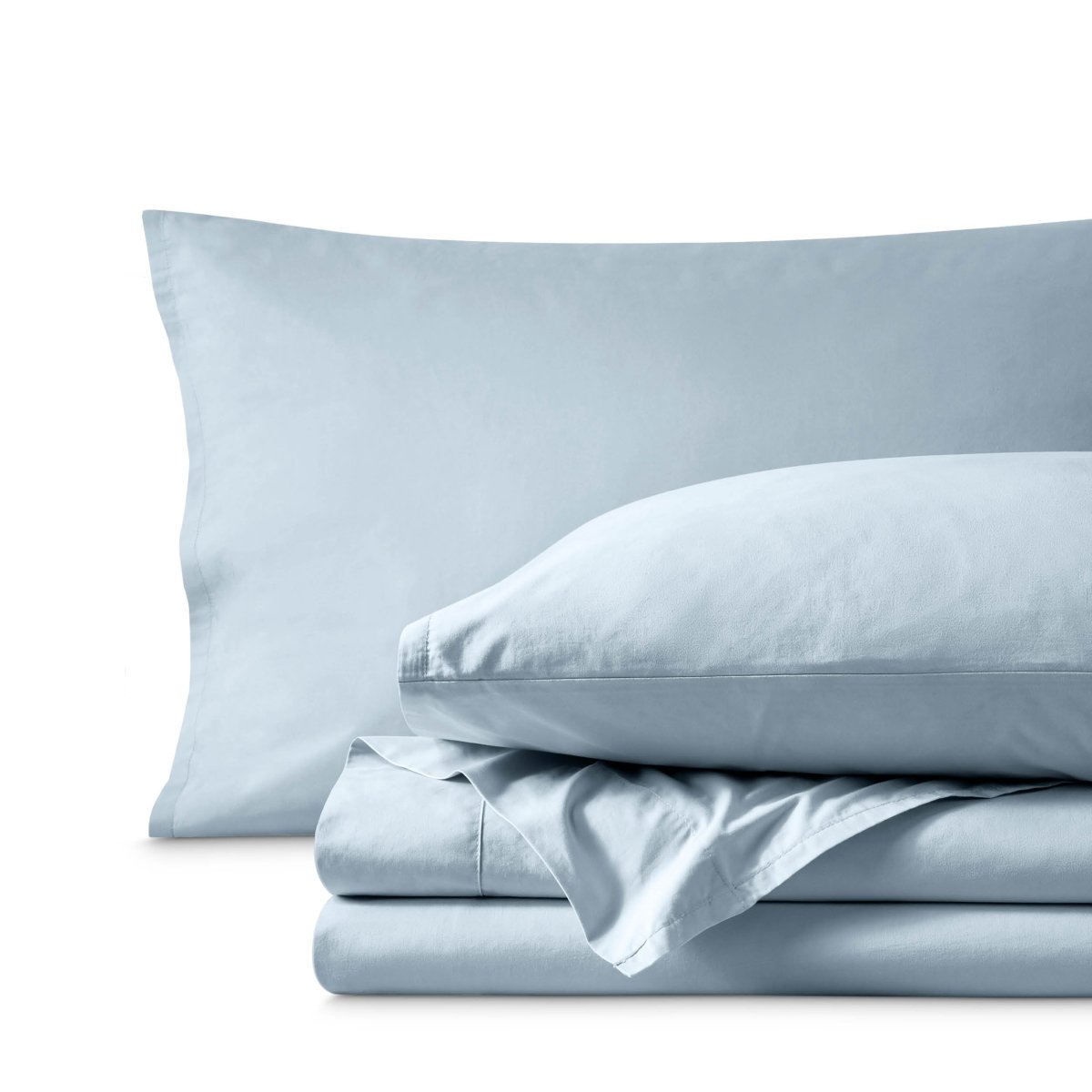 Percale bedding set including pillowcases and folded sheets arranged on a clean white background