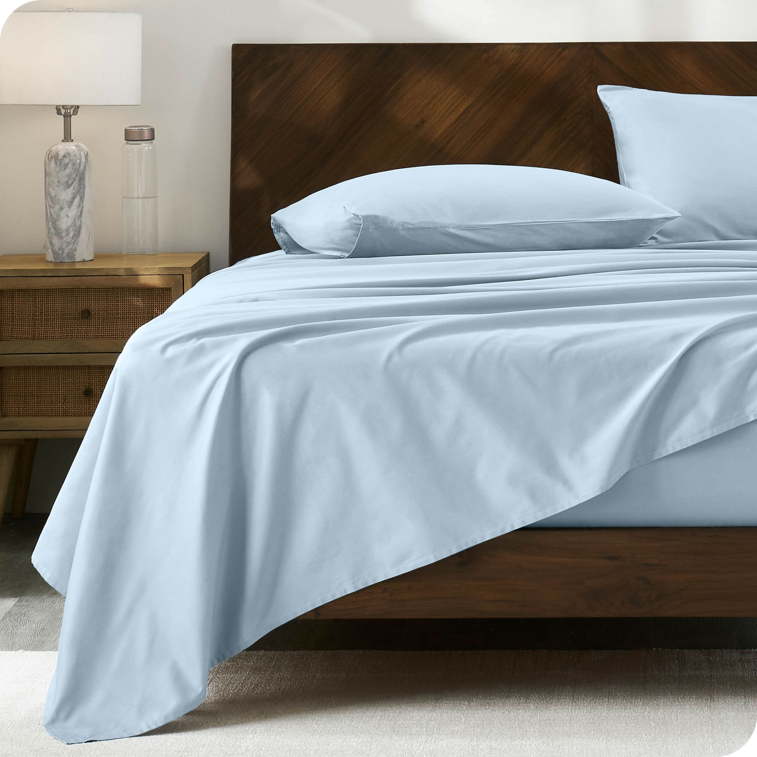 Modern wood bed with percale sheets and pillowcases