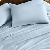 Close up of percale pillowcases and sheets on a bed