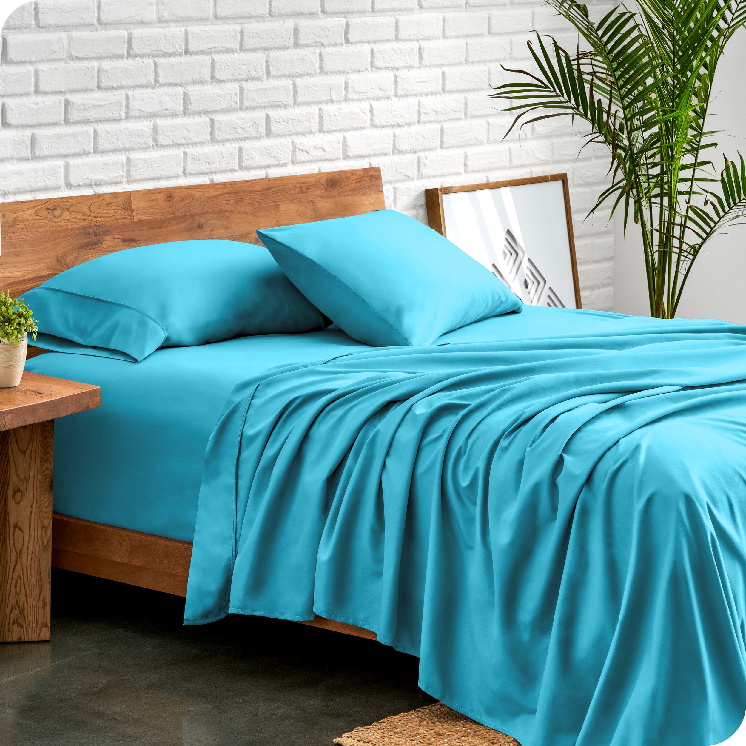 Bed with microfiber sheets against a white brick wall