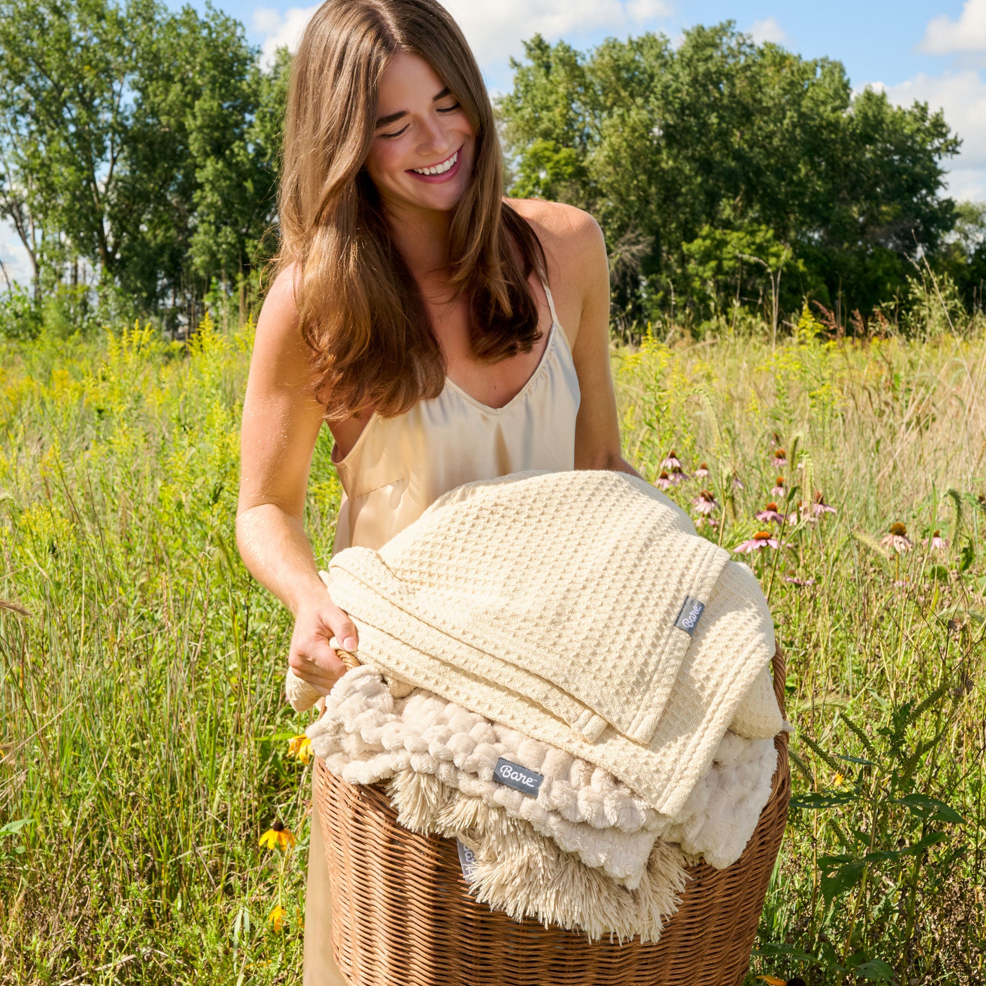 Woman in a field with basket of blankets