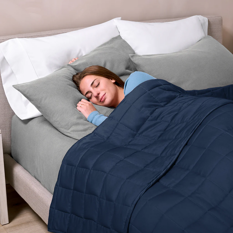 Person sleeping in bed with gray bedding