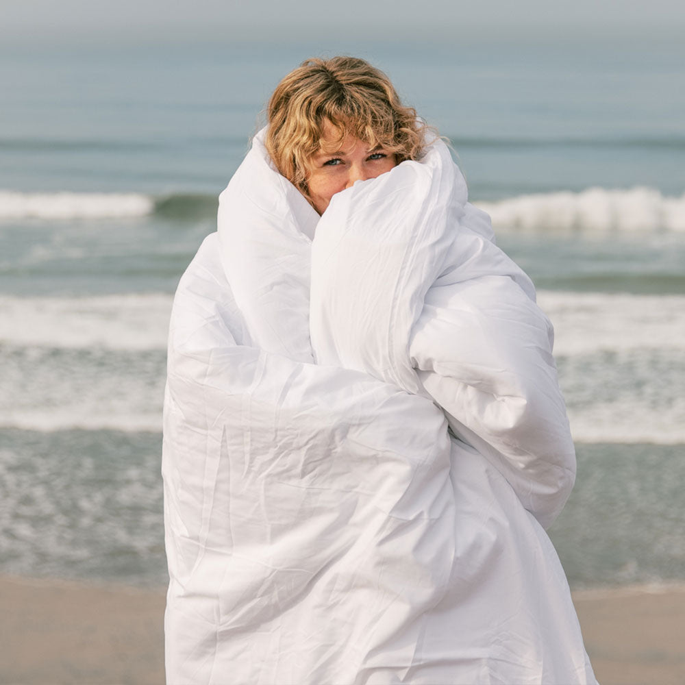 Woman wrapped in down comforter at the Beach