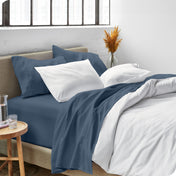 Sheets and a duvet cover on a bed in a bright bedroom