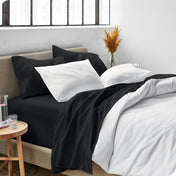 Sheets and a duvet cover on a bed in a bright bedroom