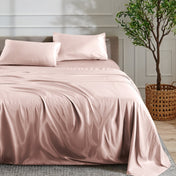 Satin bed sheet set on a bed with a plant in the background