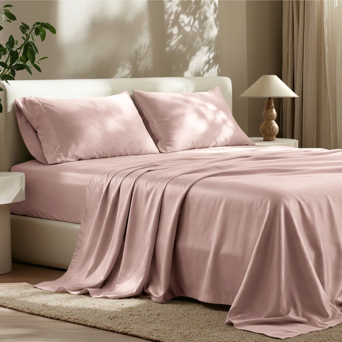 Sheet set on a bed in a bedroom with a lamp and plant.