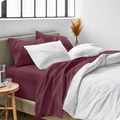 Sheets and a duvet cover on a bed in a bright bedroom