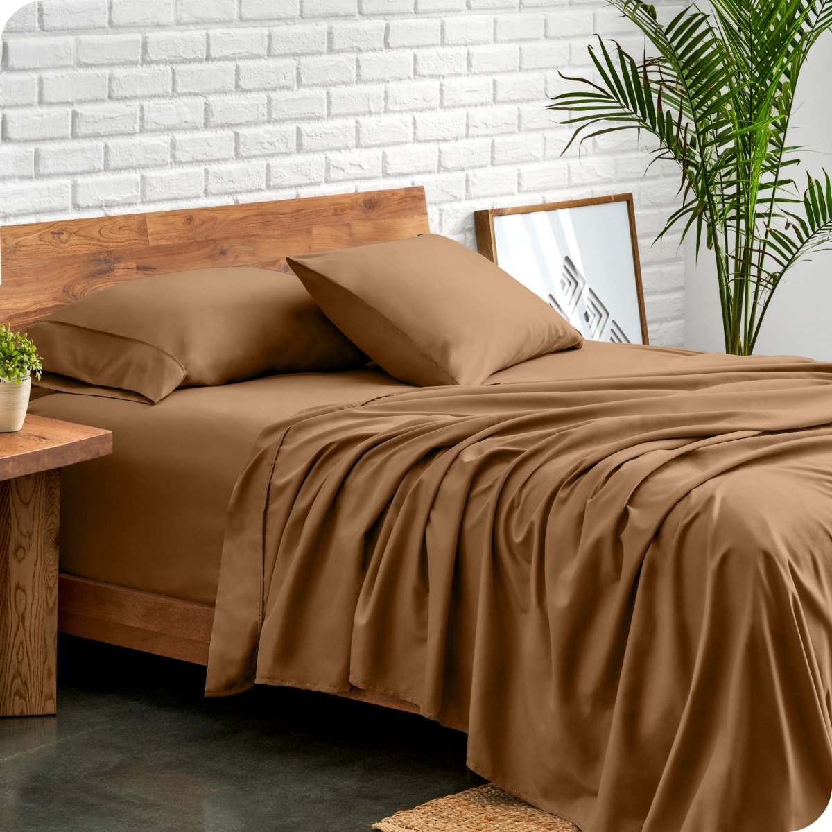 Bed with microfiber sheets against a white brick wall