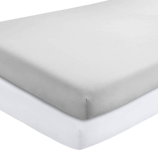 Two crib mattresses with a fitted sheets on them