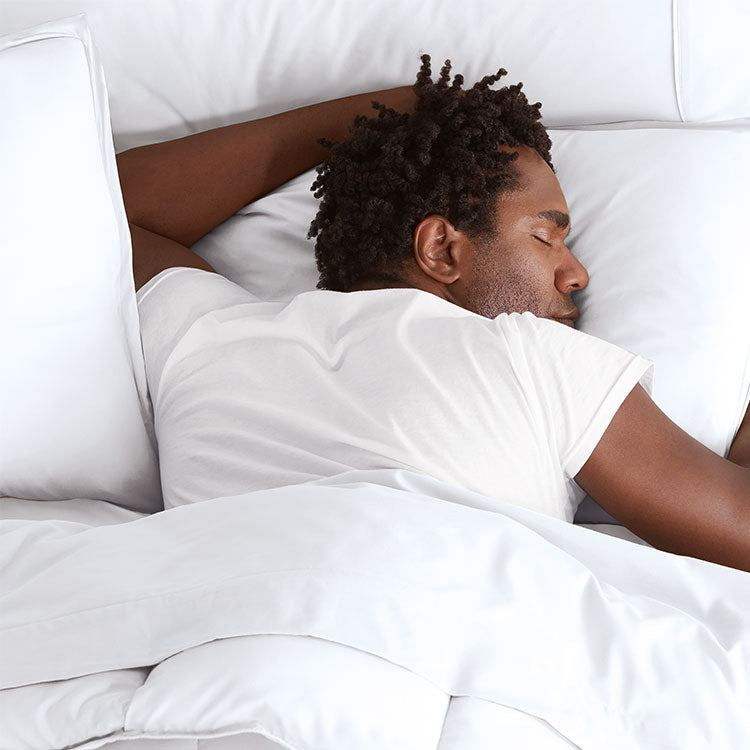 Man Laying On White Comforter