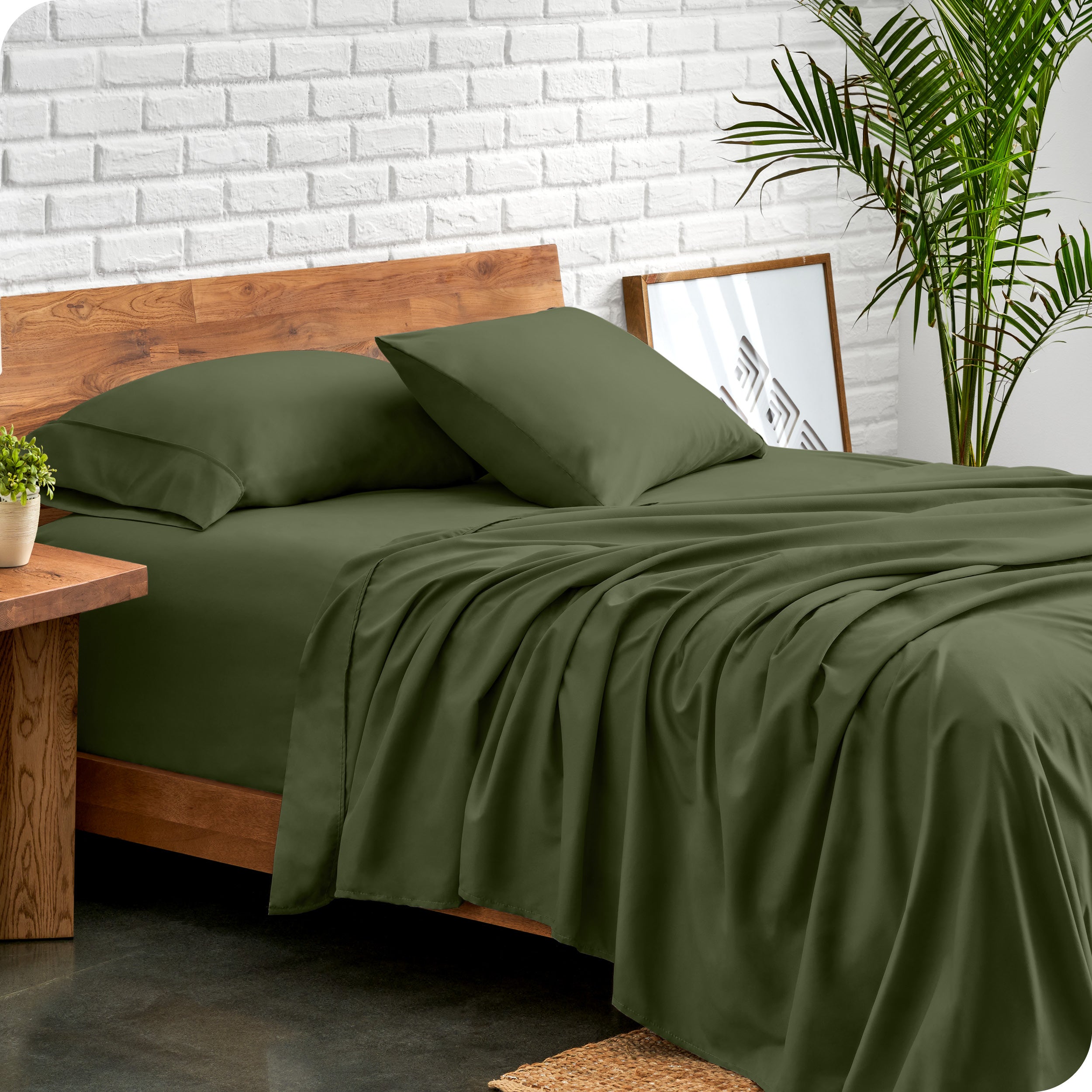 Bed with microfiber sheets against a white brick wall