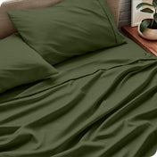 Sheet set on a bed with pillows and a plant in the background