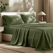 Sheet set on a bed in a bedroom with a lamp and plant.