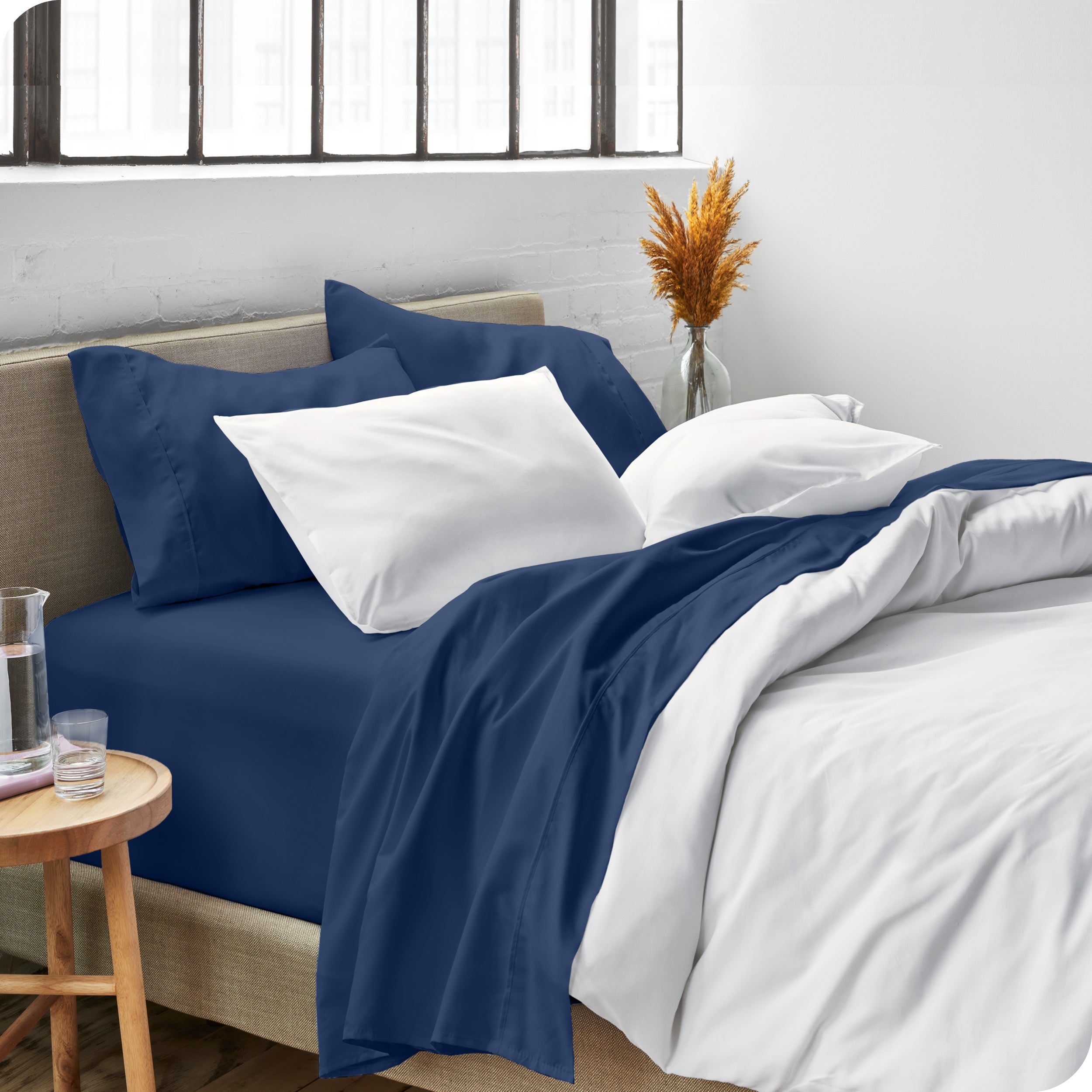 Sheets and a duvet cover on a bed in a bright bedroom