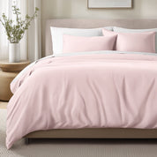 Bed with sateen bedding and pillows in a bedroom setting