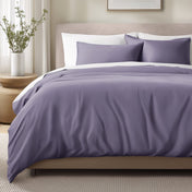 Bed with sateen bedding and pillows in a bedroom setting
