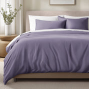 Bed with sateen bedding and pillows in a bedroom setting