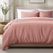 Bed with sateen bedding and pillows in a bedroom setting