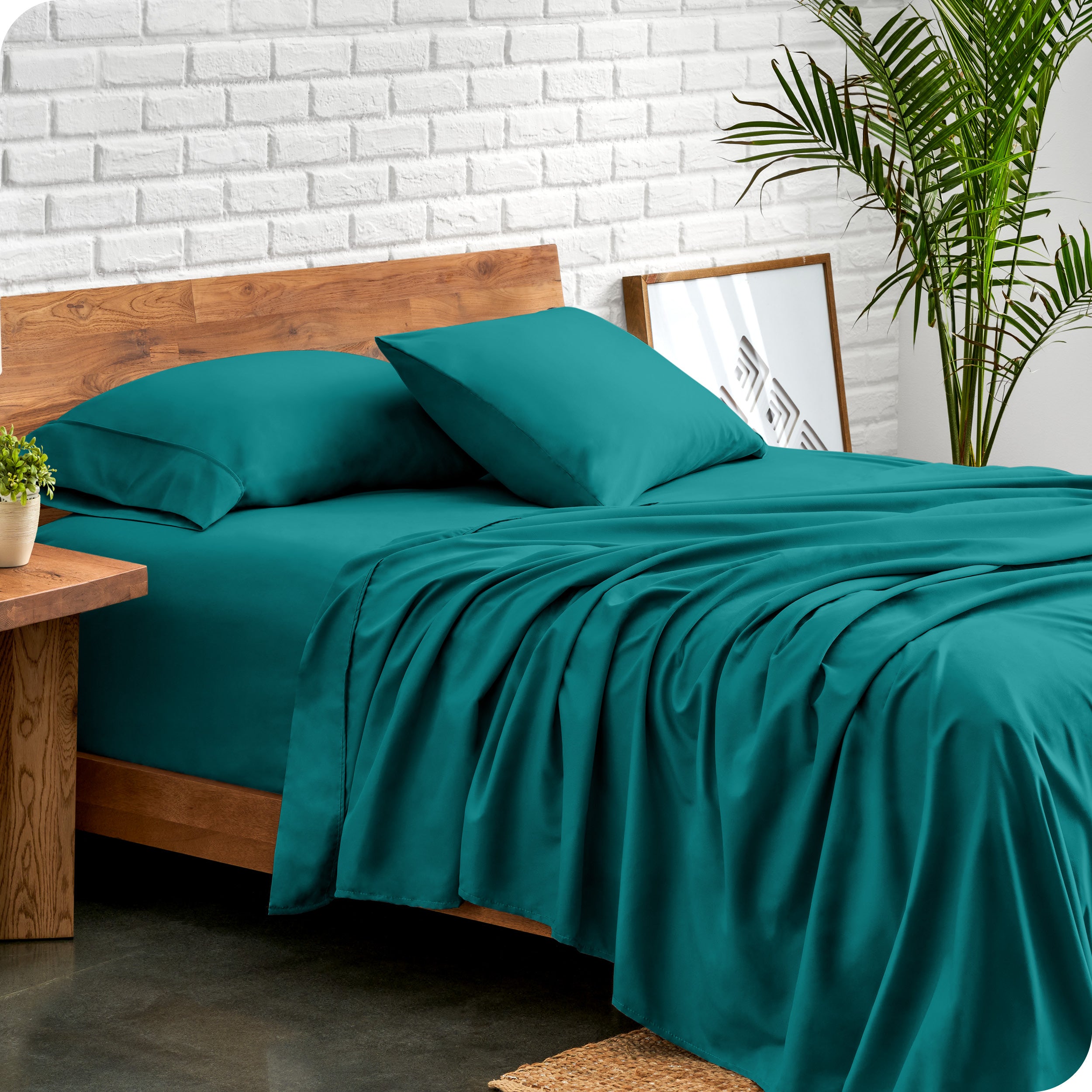 Bed with microfiber sheets against a white brick wall