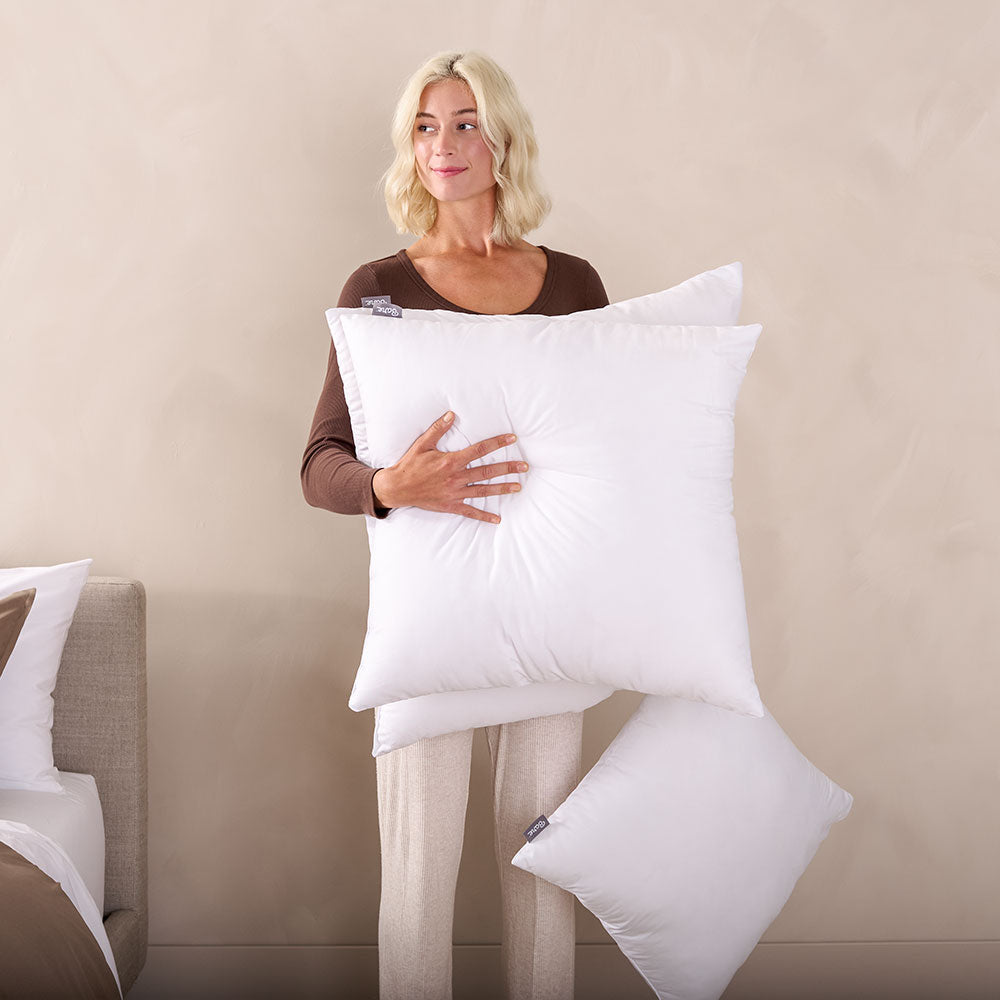 Woman holding a white decorative pillow