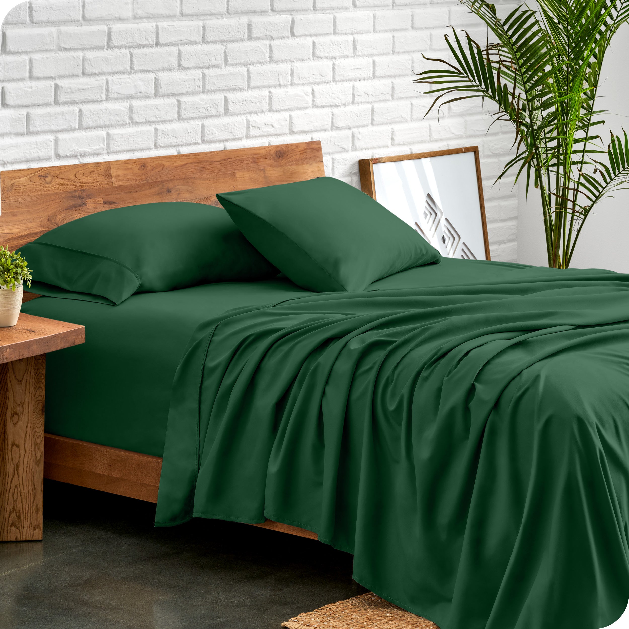 Bed with microfiber sheets against a white brick wall