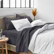 Sheets and a duvet cover on a bed in a bright bedroom