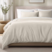 Bed with sateen bedding and pillows in a bedroom setting