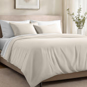Bed with organic cotton sateen bedding in a bedroom setting.